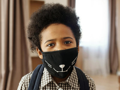 Demonstrating charlie's hair and beauty - an african american boy with an afro hairstyle wearing a creative cat-themed fac...