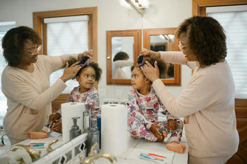 Featuring charlie's hair and beauty - a mother combs her daughter's curly hair in a cozy bathroom setting, showcasing a lo...
