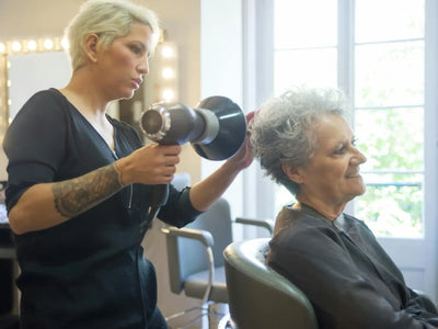 Showcasing haircut - a skilled hair stylist blow drying a senior woman's hair in a modern salon. for haircut
