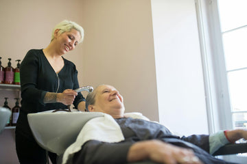 Showcasing curly - a hairdresser washes a client's hair in a modern salon in portugal, capturing a relaxed and cheerful at...
