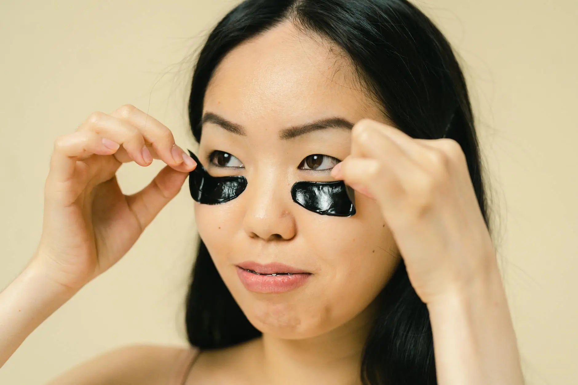 Featuring charlie's hair and beauty - close-up of a woman placing black eye patches during a skincare routine. for charlie...