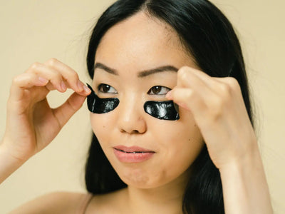 Featuring charlie's hair and beauty - close-up of a woman placing black eye patches during a skincare routine. for charlie...