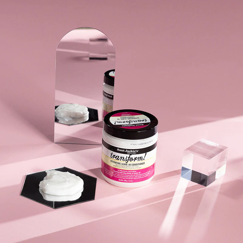 Two hair care products on a pink surface with a mirror reflection.