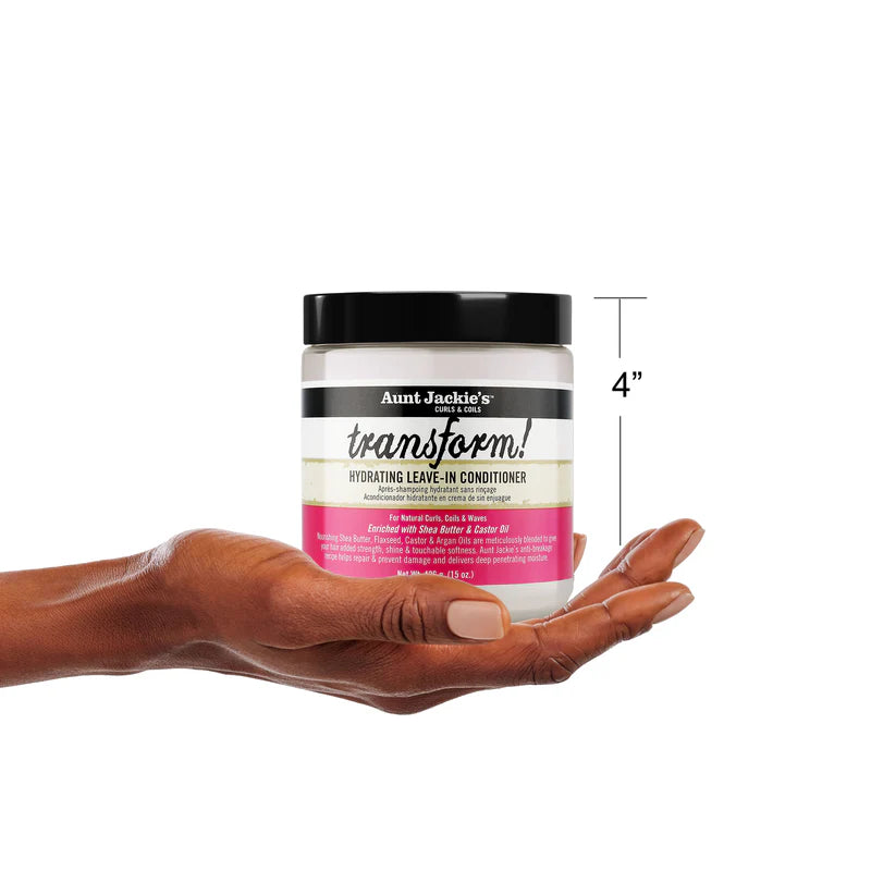 Hand holding a jar of Aunt Jackie's Transform Hydrating Leave-In Conditioner with a white background