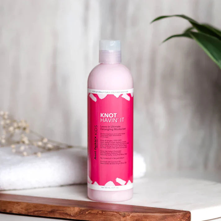 Pink bottle of 'Knot Havin' It' product on a wooden surface with a blurred background