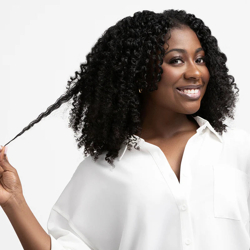 Woman with styled hair holding a braid against a white background
