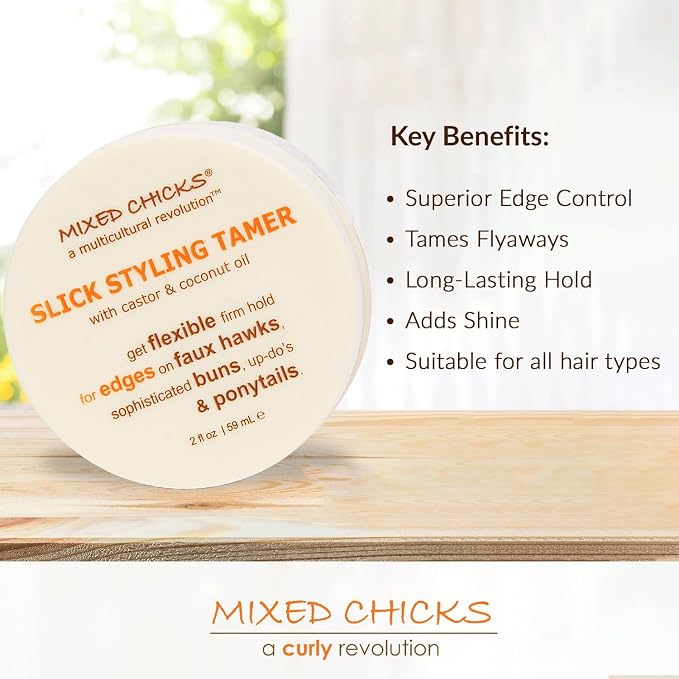 A round white jar of Mixed Chicks Slick Styling Tamer is shown on a wooden surface with a blurred indoor background. Text on the jar reads 'Mixed Chicks a multicultural revolution' and 'SLICK STYLING TAMER.