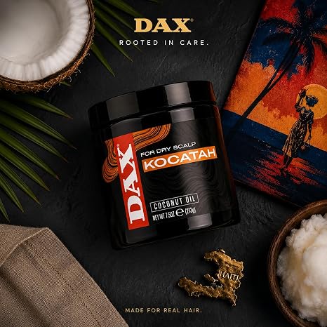 A black jar of DAX Kocatah Coconut Oil for Dry Scalp, styled in a flat-lay composition with a coconut, palm leaves, a tropical sunset print, and a bowl of white coconut wax on a dark textured background.