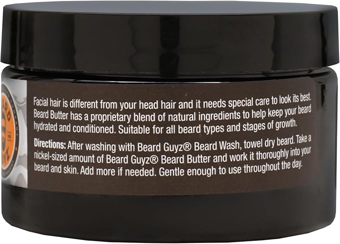 A black plastic jar of Beard Butter with a black lid, showing the back label with white text and a small orange circular graphic on the left side.