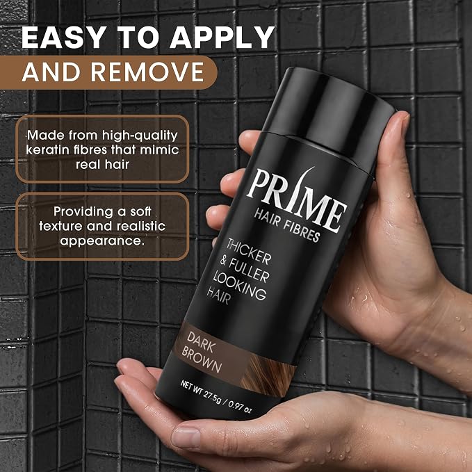A hand holds a bottle of PRIME Hair Fibres Thickener & Fuller Looking Hair in the shade Dark Brown, set against a dark tiled background with promotional text overlays.