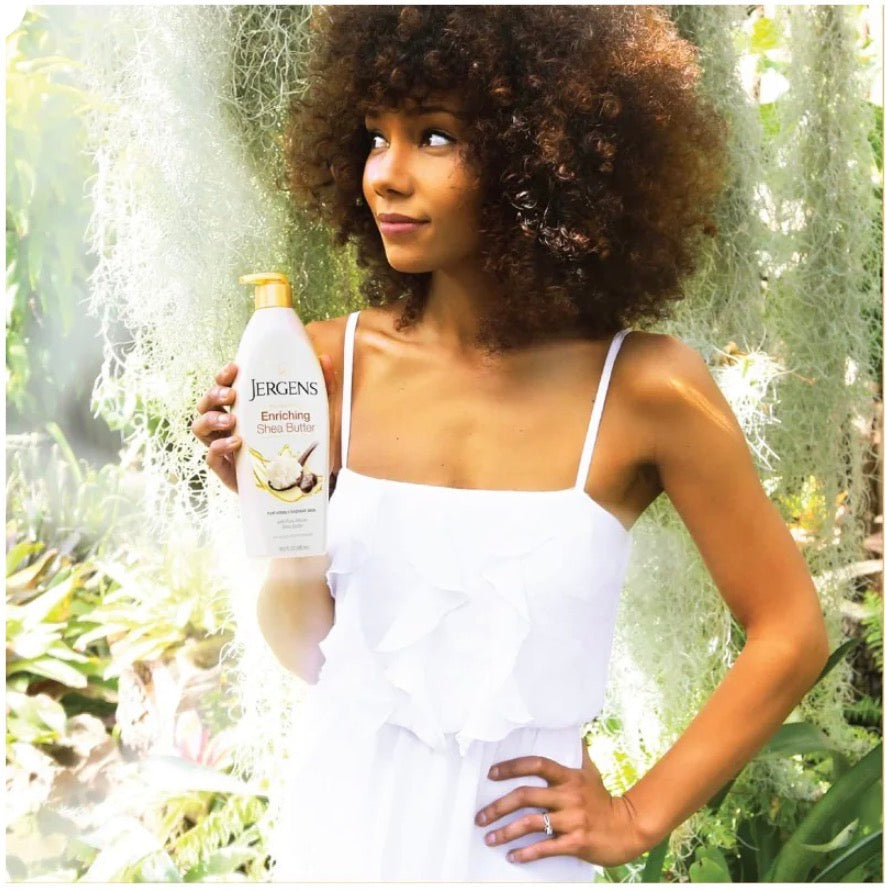Woman holding a Jergens moisturizer bottle outdoors with greenery in the background