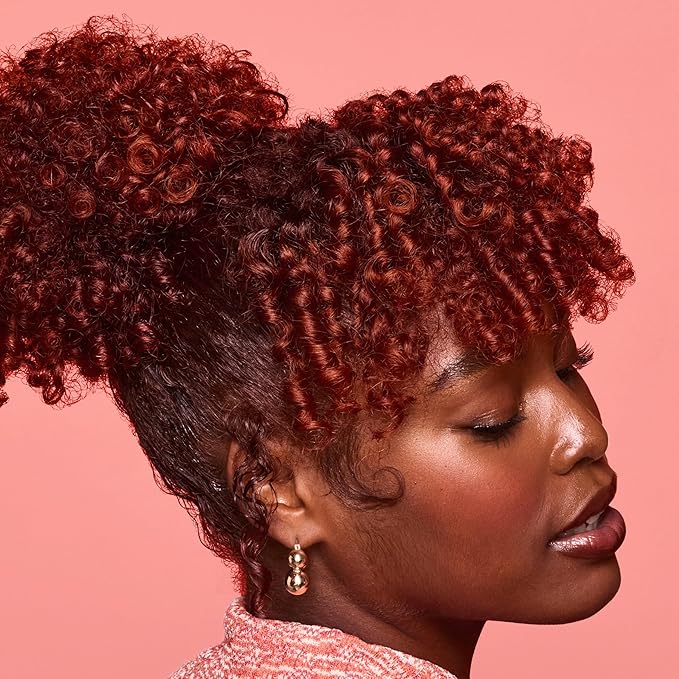 Woman with styled hair against a pink background