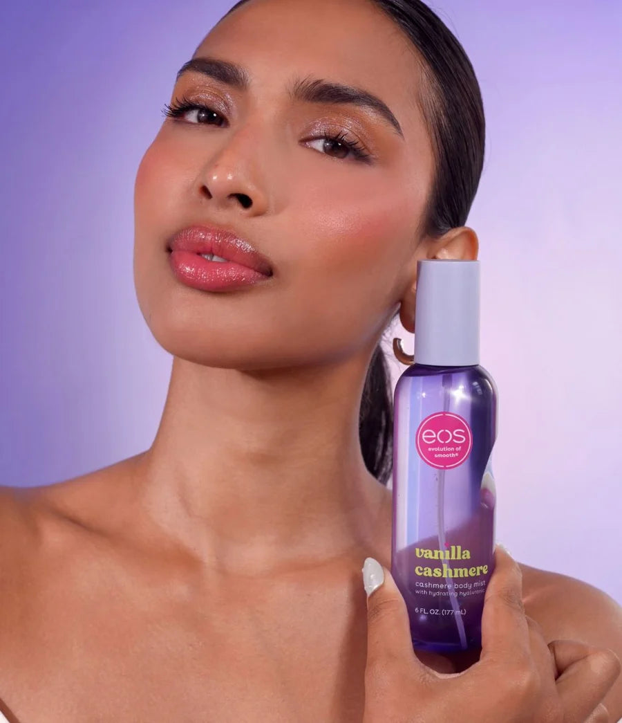 Woman holding an eos lip balm with a purple background