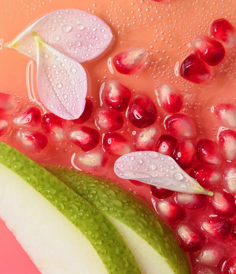 Pomegranate seeds with pear slices on a pink background
