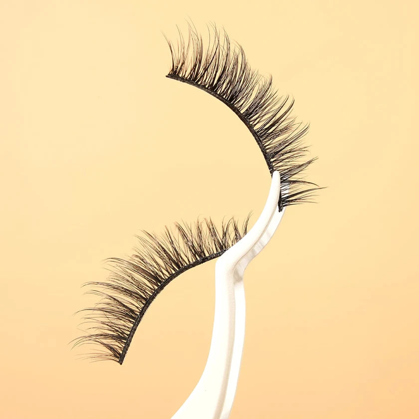Pair of false eyelashes on a beige background
