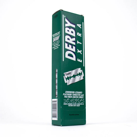 A tall green box of Derby Extra razor blades standing upright on a white background. The front and side of the packaging feature the Derby Extra branding in white, along with a silver razor graphic and product text.