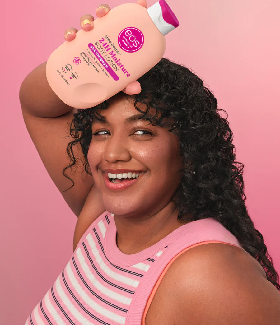 Woman holding a bottle of E3S lotion against a pink background