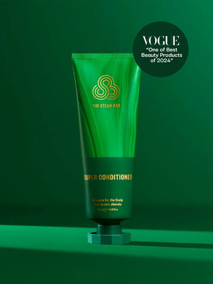 Green conditioner tube with gold text on a green background, featuring Vogue's 'One of the Best Beauty Products' 2021 label.