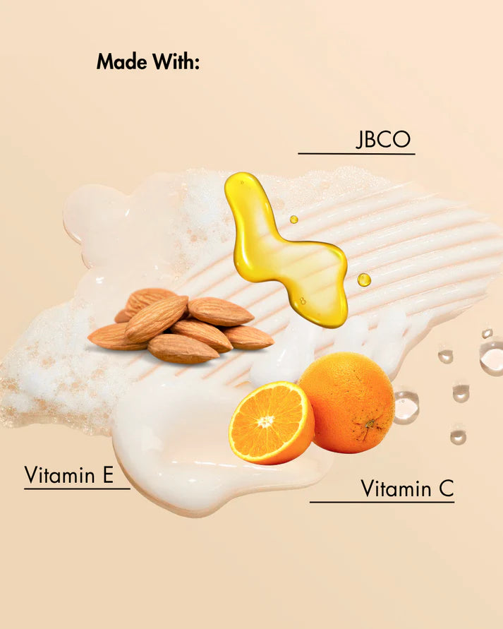 Product ingredients with almonds, oranges, and a yellow liquid labeled 'JBCO' on a beige background.