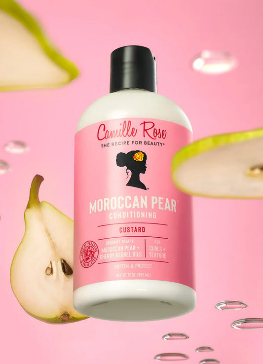Camille Rose Moroccan Pear conditioner bottle on a pink background with pears.