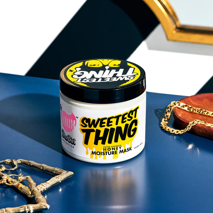 Jar of 'Sweetest Thing' honey moisture mask on a blue surface with gold chains.