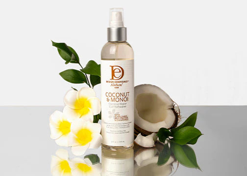 Bottle of coconut and monoi product with flowers and a coconut on a white background