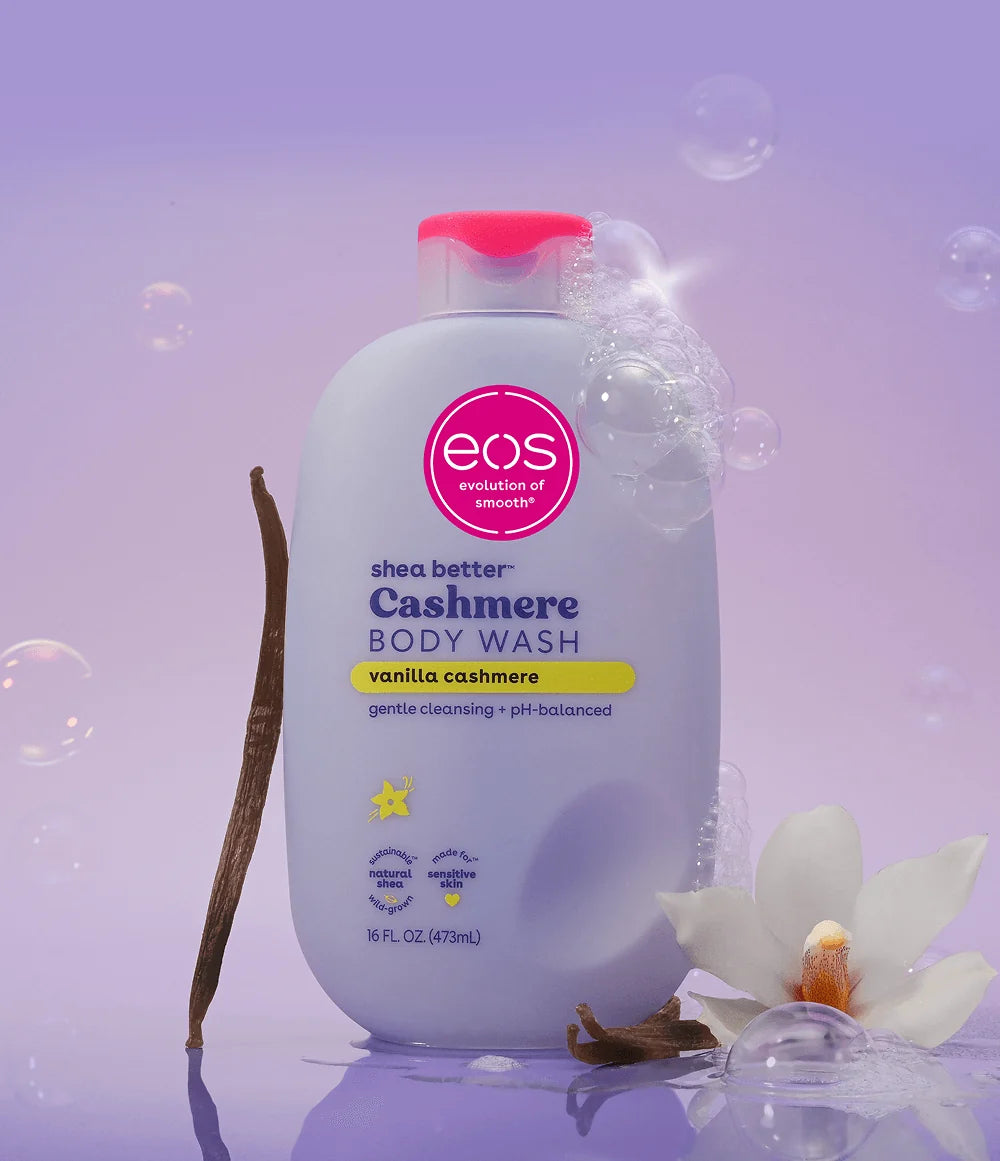 eos shea butter cashmere body wash bottle on a purple background with vanilla bean and flower.