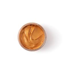 Jar of gold-colored cream or paint on a white background
