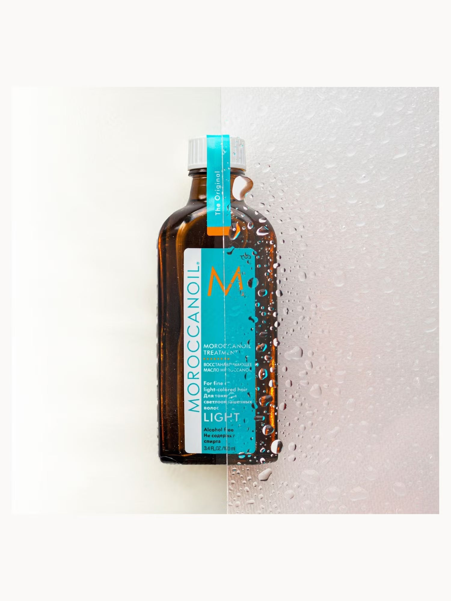 Moroccanoil bottle on a textured white background