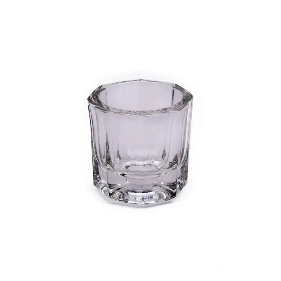 A small clear glass shot glass with a faceted, octagonal design, shown on a plain white background.