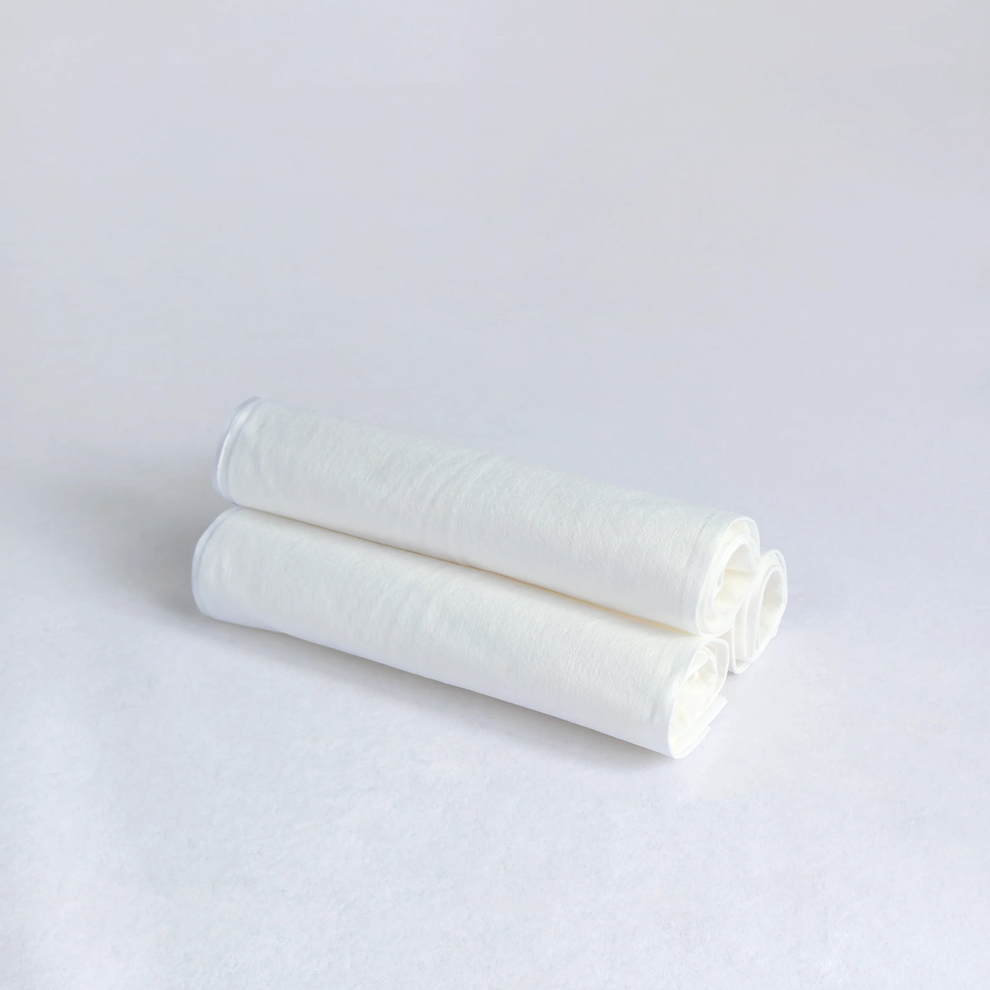 Two white cylindrical objects on a light gray background