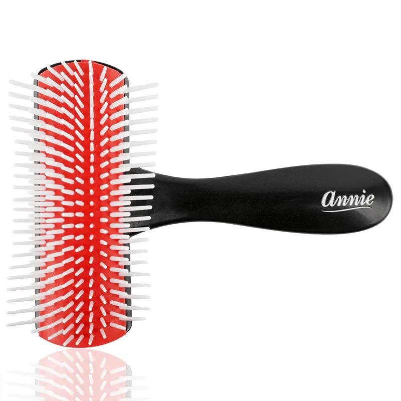 Hairbrush with red and white bristles and black handle on a white background