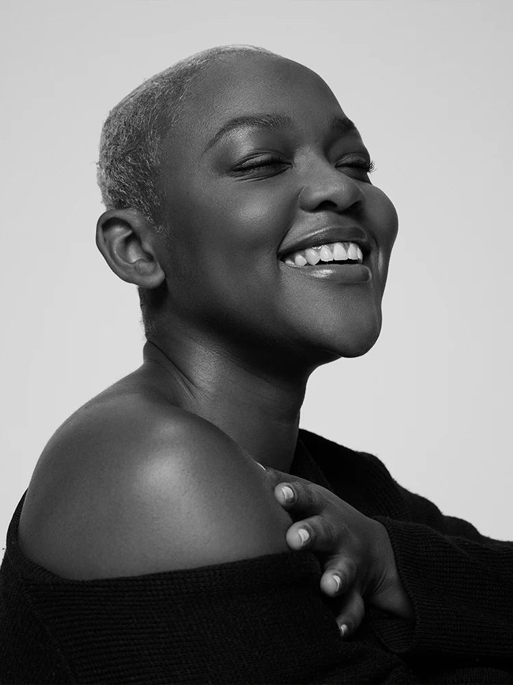 Black and white portrait of a woman with a short haircut, smiling.