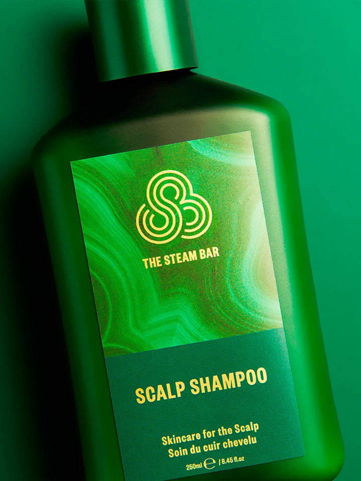 Green bottle of scalp shampoo from The Steam Bar on a green background