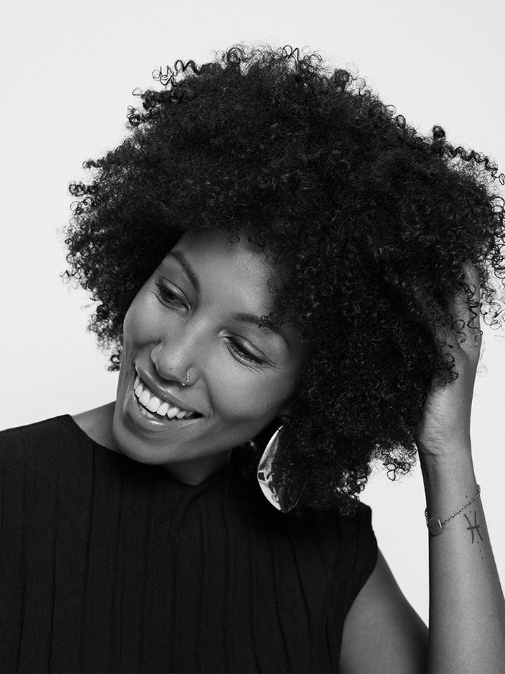 Black and white portrait of a woman with an afro, wearing a sleeveless top.