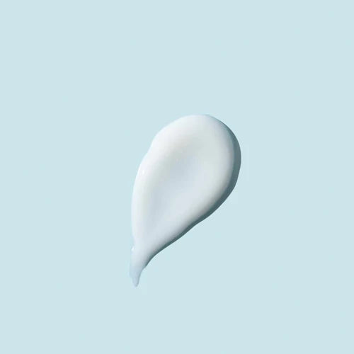 A smooth, teardrop-shaped dollop of white cream or lotion centered on a solid pale blue background.